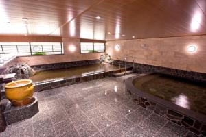 ein großes Bad mit Badewanne in einem Gebäude in der Unterkunft Natural Hot Spring Yaoji Hakata Hotel in Fukuoka