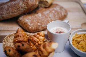 uma mesa com um prato de pão e uma chávena de café em DC Hotel Charleroi Airport em Charleroi