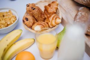 uma mesa coberta com uma tigela de pão e um copo de sumo de laranja em DC Hotel Charleroi Airport em Charleroi