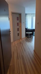 un salon vide avec une porte et une table dans l'établissement Angel Apartament, à Władysławowo