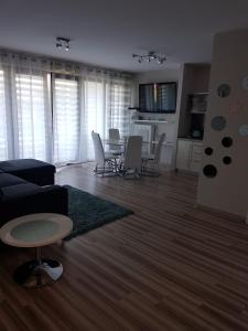 - un salon avec un canapé, une table et des chaises dans l'établissement Angel Apartament, à Władysławowo