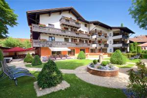 ein großes Apartmenthaus mit einem Garten davor in der Unterkunft Hotel Hirsch in Oberstaufen