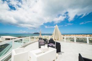 a balcony with chairs and an umbrella and the ocean at Hotel Boutique TAO Caleta Mar in Corralejo