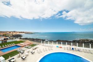 an aerial view of a resort with a pool and the ocean at Hotel Boutique TAO Caleta Mar in Corralejo