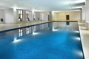 una grande piscina con piastrelle blu in un edificio di Ani Grand Hotel Yerevan a Yerevan