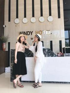 洞海Windy Hotel Quang Binh的两名妇女站在旅馆前