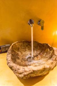 lavabo de piedra en el baño con grifo en Margarita Hotel, en Firostefani