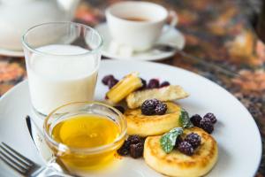 einen Teller mit Obst und ein Glas Milch. in der Unterkunft Atrium Hotel in Iwano-Frankiwsk