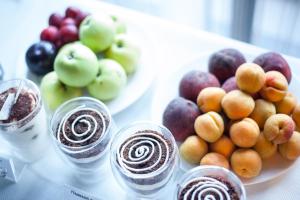 een tafel met glazen chocolade en een fruitschaal bij Light Hotel in Dnipro