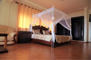 um quarto com uma cama de dossel em The Palms Beach Hotel em Entebbe