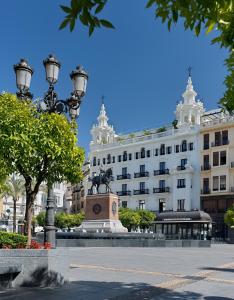 um edifício com uma estátua em frente em H10 Palacio Colomera em Córdoba