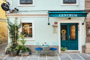 una mesa y sillas frente a un edificio con una puerta azul en Guesthouse Centrum B&B, en Izola