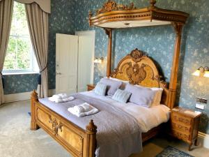 een slaapkamer met een hemelbed en 2 handdoeken bij Netherdale House & The Coach House in Turriff