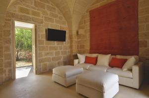 a living room with a couch and a tv at Masseria Trapana in Lecce