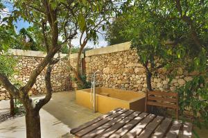 a bath tub sitting next to a stone wall at Masseria Trapana in Lecce