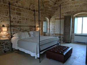 a bedroom with a bed in a stone wall at Masseria Trapana in Lecce