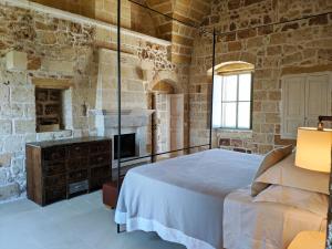 a bedroom with a large bed and a fireplace at Masseria Trapana in Lecce