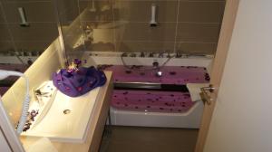 a bathroom with a purple bath tub and a sink at Hollywood Hotel in Sarajevo