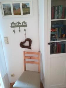 um quarto com uma porta, uma cadeira e livros em Haus Toni em Bad Füssing