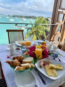 een tafel met een bord eten en uitzicht op de oceaan bij Azure Beach Boutique Hotel in Grand Baie