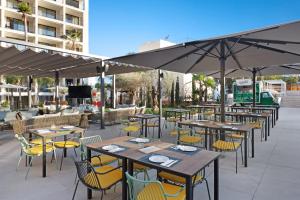 an outdoor patio with tables and chairs and umbrellas at Hotel Paradiso Garden in Playa de Palma