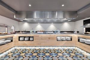 a large kitchen with a counter in a restaurant at Hotel Paradiso Garden in Playa de Palma