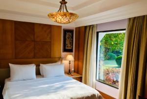 um quarto com uma cama e uma grande janela em Trident Bhubaneswar em Bhubaneshwar