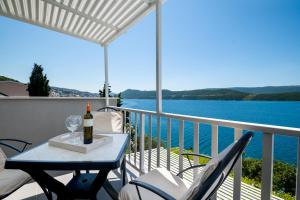 een tafel met een fles wijn op een balkon bij Apartments Lukrecia in Neum