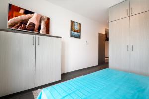 een slaapkamer met witte kasten en een blauw bed bij Apartments Lukrecia in Neum