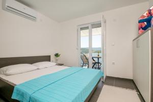 een slaapkamer met een bed en een balkon met een tafel bij Apartments Lukrecia in Neum