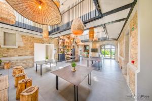 a room with tables and chairs in a building at Domaine de Ronchinne - Maison du Jardinier in Maillen