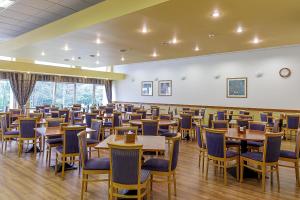 a dining room with wooden tables and chairs at Medical SPA "Eglės sanatorija" Standard Druskininkai in Druskininkai