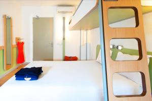 een slaapkamer met een wit bed en 2 ramen bij ibis budget Gare de Poitiers in Poitiers