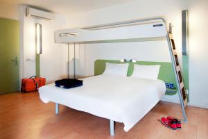 een slaapkamer met een wit bed en een baldakijn bij ibis budget Gare de Poitiers in Poitiers