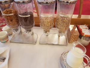 une table avec quatre verres de différents types de denrées alimentaires dans l'établissement Hotel Hahnenkleer Hof, à Hahnenklee