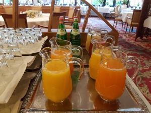 - un plateau avec plusieurs verres de jus d'orange sur une table dans l'établissement Hotel Hahnenkleer Hof, à Hahnenklee