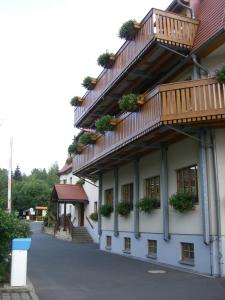 a building with balconies and potted plants on it at Rübezahlbaude in Großschönau