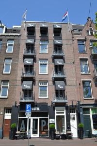 - un grand bâtiment en briques avec des balcons dans une rue dans l'établissement Alp Hotel, à Amsterdam