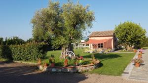 een huis met een boom en bloemen in een tuin bij Casal Sant'Elena in Altopascio