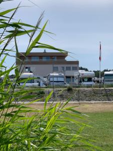 ein Gebäude mit Bussen auf einem Parkplatz in der Unterkunft Hotel Strandhus in Cuxhaven