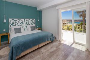 Mareta View - Boutique Bed & Breakfast في ساغريس: غرفة نوم بسرير ونافذة كبيرة