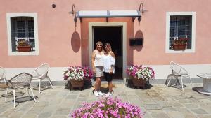 twee vrouwen staan voor een gebouw met bloemen bij Casal Sant'Elena in Altopascio