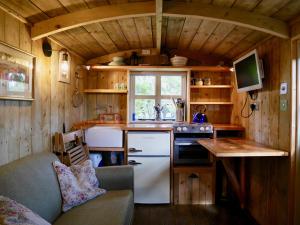 a kitchen in a tiny house with a sink and a stove at The Wayside Shepherd Hut in Beaulieu