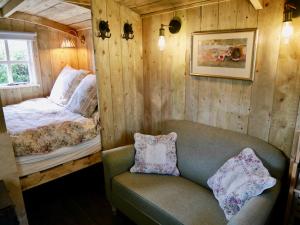 a room with a bed and a couch and a chair at The Wayside Shepherd Hut in Beaulieu