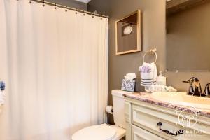 a bathroom with a shower curtain and a toilet and a sink at Bouchard Restaurant & Inn in Newport