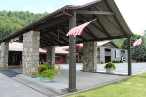 un pavillon avec drapeaux américains devant un bâtiment dans l'établissement Great Smokies Inn - Cherokee, à Cherokee