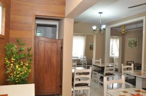 a dining room with a wooden door and a table and chairs at Pousada Villa Vecchia in Canela