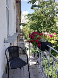 una silla negra sentada en un balcón con flores en Sija's house, en Kaunas