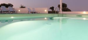 una piscina con sillas frente a una casa en Mediterraneo, en San Teodoro