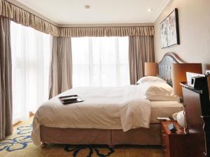 1 dormitorio con cama grande y ventana grande en Ramada Plaza Tianlu Hotel, en Wuhan